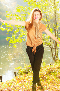 年轻女子在秋天公园散步时装放松自然概念举手的女孩图片
