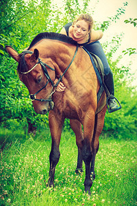 骑马的动物理念坐在上拥抱它的年轻女拥抱和的年轻女拥抱和坐在马的年轻女图片