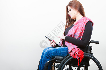 有平板电脑的年轻残疾妇女在互联网上轮椅冲浪的女孩健康残疾爱好因特网技术概念有平板电脑的年轻残疾妇女图片