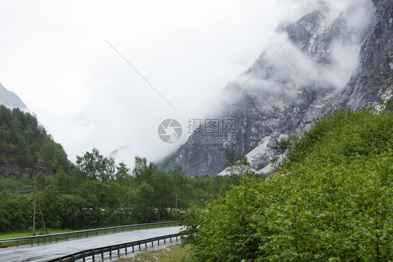 穿过挪威山的通路雾雨日美丽的绿色夏季风景旅行和游图片