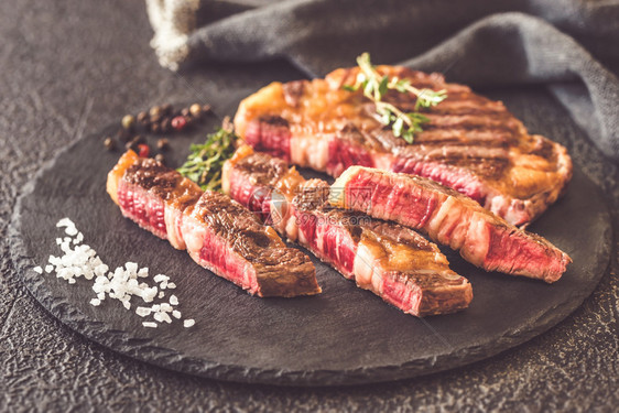 马铃薯和肉盘上的炸土豆和生鲜牛排图片