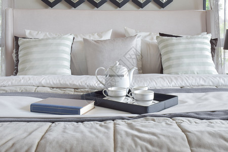现代卧室床上装饰用书和茶叶的托盘图片