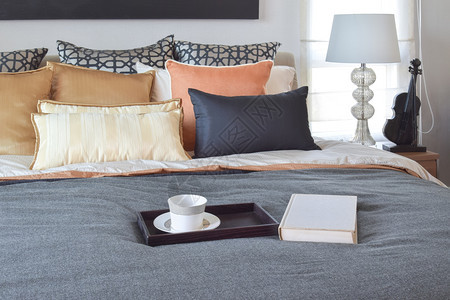 现代卧室内装饰的木板上茶杯和床白书装饰的茶杯图片