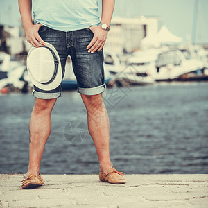 与游艇一起在港口码头旅游的男子双腿紧闭享受暑假的男子在海上旅行全程图片