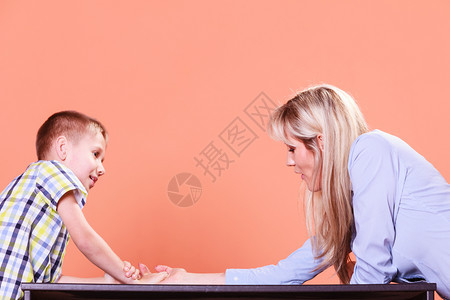 与家庭乐趣和纽带共度时光母亲和儿子在室内摔跤和玩乐母亲儿子在桌上摔跤图片