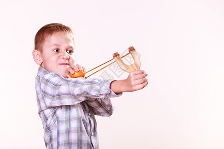 童年玩木棍和水果瞄准的普通话年轻男孩用木棍打的普通话图片