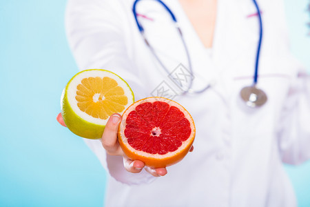 健康概念营养医生将水果葡萄握在她手上的蓝色水果食品建议健康饮图片