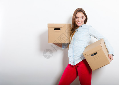 快乐的女子搬进装箱房屋年轻女子在新公寓内安放衣和拆行李快乐的女子搬进装箱房屋图片