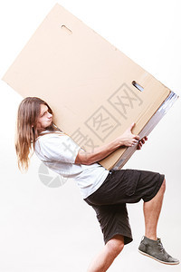 年轻男邮递员拿着重的立方体包装箱送货员拿着纸盒图片