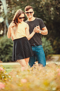 年轻女孩和男在公园里玩手牵年轻夫妇在公园里共度时间图片