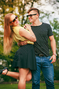 快乐的情侣穿着太阳眼镜的年轻情侣在夏日公园露天约会快乐的情侣在公园图片