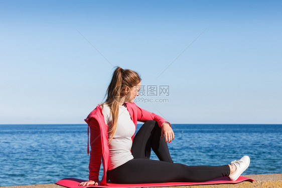 女在户外运动后休息在海边运动服上穿的适合身体女孩休息图片