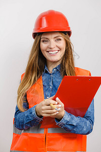 妇女建筑工人结构程师穿橙色背心红头盔有笔文件垫工业作安全室拍摄灰色女工程师建筑头盔图片