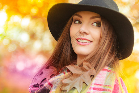 秋天公园中迷人的年轻微笑女肖像时装女孩穿着红色毛衣围巾和黑帽子秋天公园中美丽的女图片