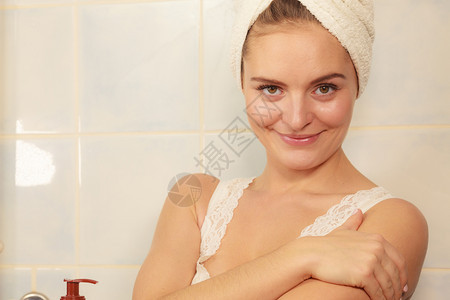 女在浴室用润湿剂乳油滑在身体上涂润滑剂皮肤科温泉治疗在身体上涂润滑剂奶油的妇女图片