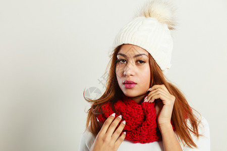 时装雪中间人的概念穿红冬服的女人穿着暖帽和围巾的穆拉托模特儿图片
