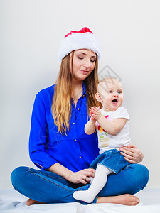 圣诞节家庭日概念母亲戴着圣达克萨斯帽子抱着婴儿图片
