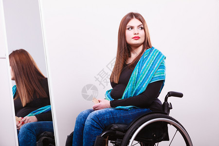 残疾病轮椅悲剧概念残疾女孩用梳子看复发年轻时髦的残疾女孩用蓝围巾照镜子残疾女孩用复发图片