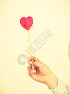 情人节白天礼物概念持有爱牌的妇女心形木棍持有心形手棒的妇女心形手棒图片