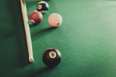 Billiard球和杆粘在绿色桌上池球游戏史努克和坚持在台桌上图片