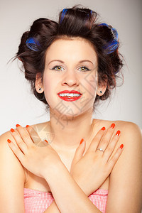 年轻女孩准备参加晚会头发卷的年轻女人肖像红嘴唇和指甲室的化妆品在灰色上拍摄发型和美甲图片