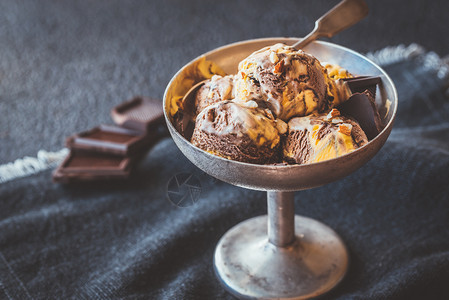 巧克力冰淇淋上有碎坚果背景图片