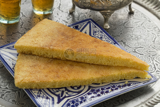 传统的摩洛哥harcha块盘上塞莫利纳面包和茶叶图片