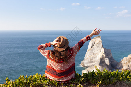 穿着旅行服和帽子坐着看蓝色的海洋和天空旅行概念照片穿旅行服和帽子坐着看蓝色的海洋和天空图片