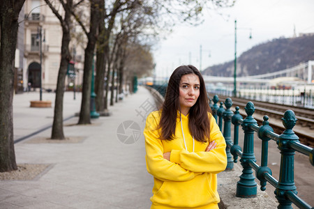 时尚的年轻女穿着黄帽装扮成城市街道风格的女图片