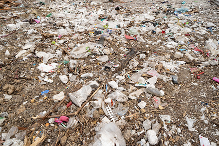 在环境污染概念中在城市一堵墙附近存放各种不同类型的大垃圾堆塑料袋和垃圾桶图片