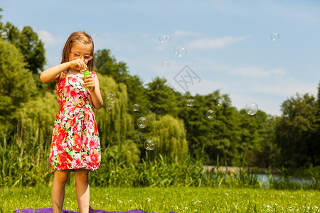 小女孩在公园吹肥皂泡图片