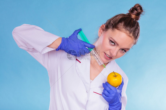 科学家医生用注射器苹果持有转基因水果的女化学家转基因食品改制科学医生注射苹果转基因食品图片