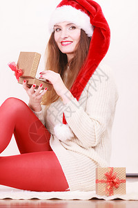 穿着圣达克萨斯帽子的开心女人金礼物盒带珍珠圣诞节时间赠与和幸福概念图片