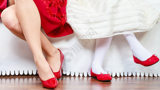 优雅和风格坐在沙发上的两个时髦优雅女母亲和儿穿红鞋双腿和女儿穿红鞋双腿和穿红鞋和穿红鞋图片