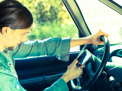 现代技术概念人驾驶汽车时使用移动电话检查社交媒体或设置导航人驾驶汽车时使用手机图片