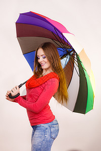 穿着红衣站在多彩雨伞下玩乐的时装髦笑脸的女孩气象预报和天季节概念妇女在多彩雨伞下站立图片