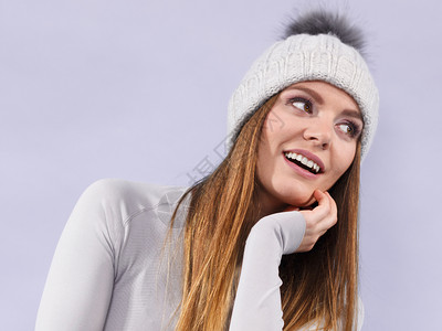 在冬季羊毛帽和灰色运动中有吸引力的妇女在紫外线拍摄的滑雪训练演播室中穿热内衣的女子图片