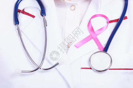 妇女为健康而斗争乳腺癌肿瘤概念白色医疗围裙制服上的粉色丝带和蓝听诊器穿医疗制服的粉色丝带和听诊器图片