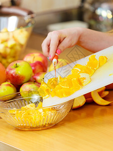 家中厨房的年轻女家庭主妇在切菜板上开新鲜的橙子水果用于沙拉或多汁健康饮食烹饪生品饮和人的概念图片