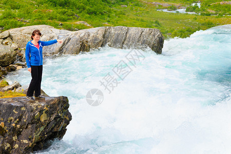 旅行自然美的丽旅游女在挪威观看Videfossen称为Buldrefossen瀑布图片