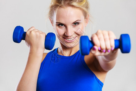 运动型妇女举起轻哑铃重量合适的女孩锻炼肌肉健身和体力建设合适的妇女举起哑铃重量合适的妇女举起哑铃重量图片