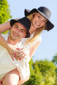戴着太阳帽子的男人和金发女在公园里有浪漫的约会快乐在一起图片
