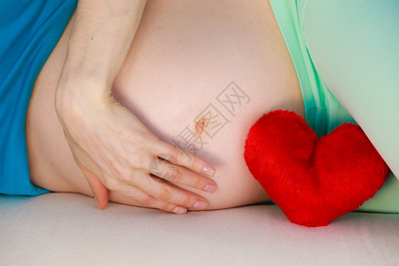 孕妇躺在沙发上抚摸肚子图片