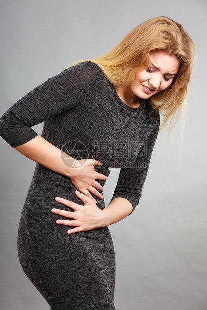 女腹部疼痛用灰色手抱腹部女疼痛图片