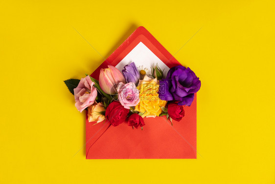 开放红信封有黄色背景的花朵安排最高视图节日问候概念打开红信封图片