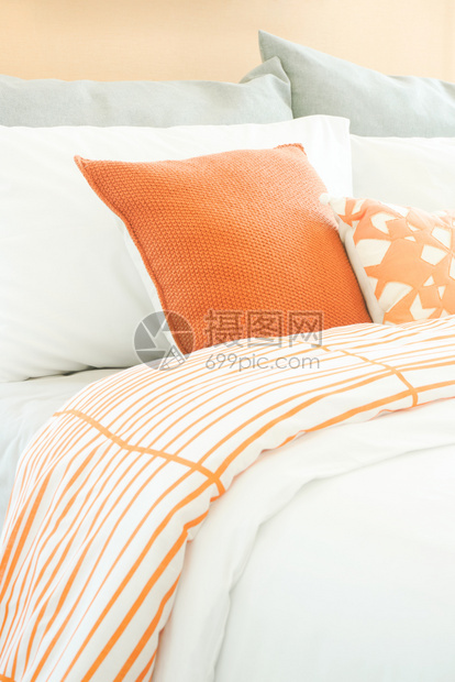 床上橙色和灰的闭合枕头图片