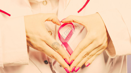 关紧女医生的手会用粉色丝带符号做心脏帮助和慈善过滤手心会用粉色丝带符号做心脏图片