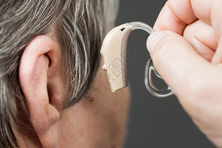 保健听力放大聋人设备使用助听器的高级妇女图片