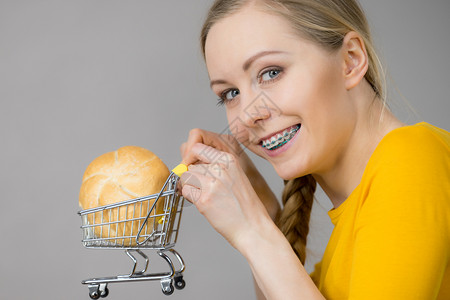 购买谷类食品产概念幸福妇女拿着面包卷的购物车厢幸福妇女拿着面包的购物车幸福妇女拿着面包的购物车图片