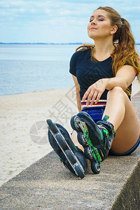 有吸引力的年轻女子穿着溜冰鞋乘飞机后放松女在夏季海边玩得开心女孩在海边穿着溜冰鞋图片